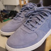 Lila sneakers i mocka som representerar 90-tals kläder.